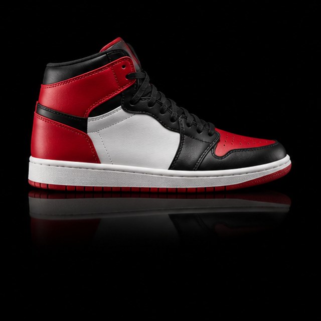 Sneaker alto rojo, blanco y negro sobre fondo negro