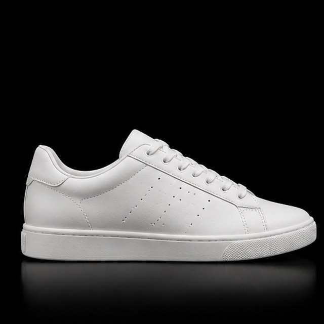 Sneaker blanco de piel de corte bajo sobre fondo negro